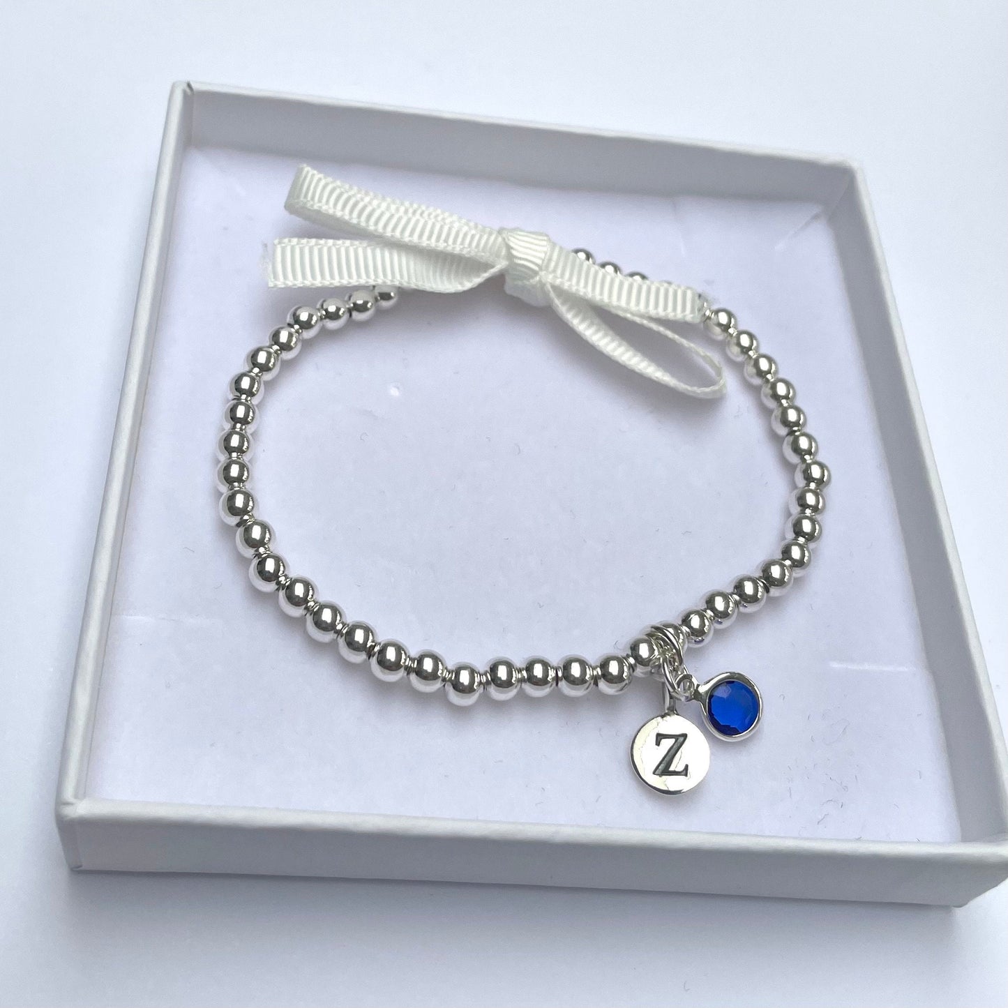 Silver-plated elasticated bead bracelet with silver initial & birthstone charm