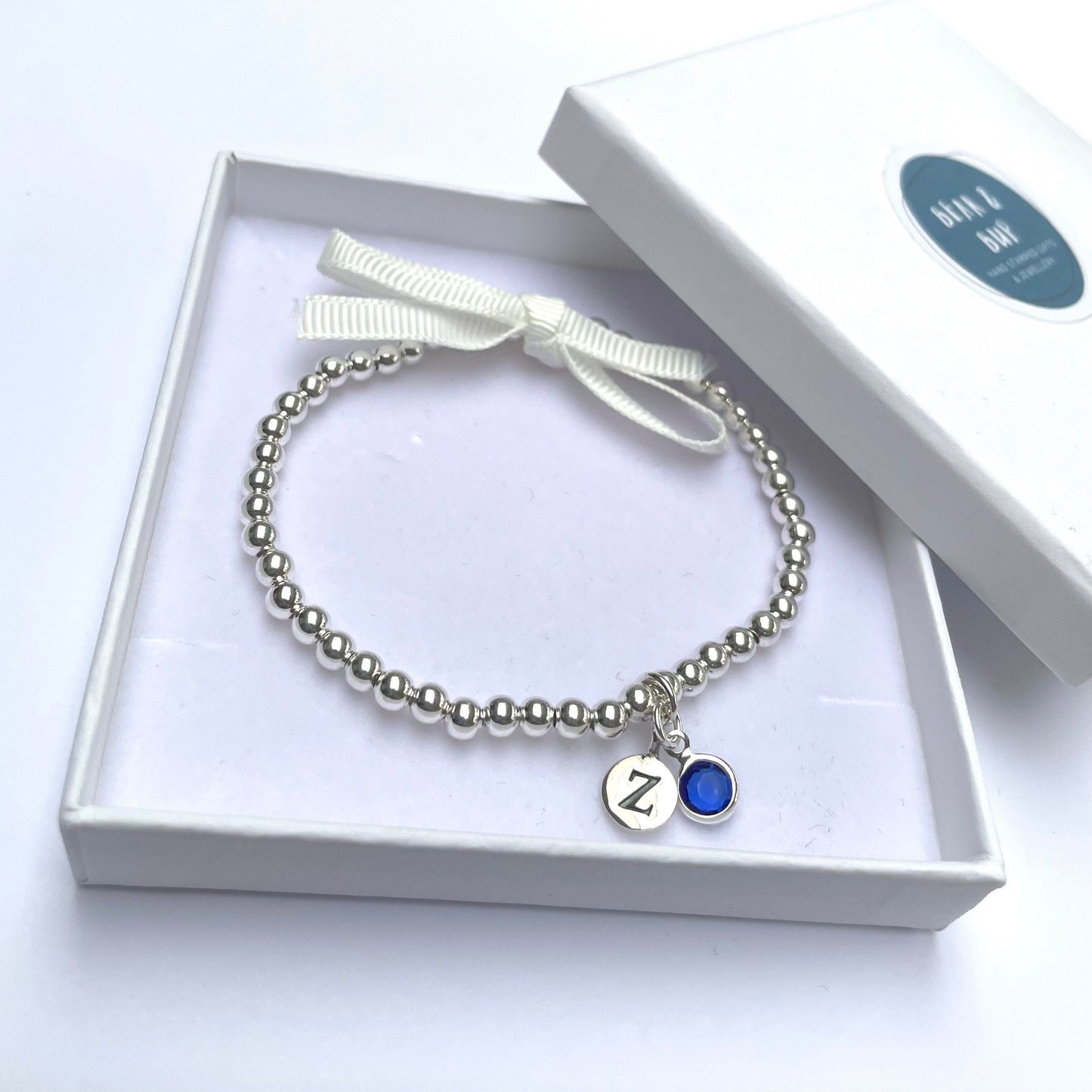 Silver-plated elasticated bead bracelet with silver initial & birthstone charm